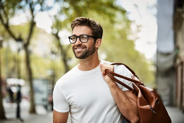Smiling businessman with brown bag walking in city businessman walking in LA city